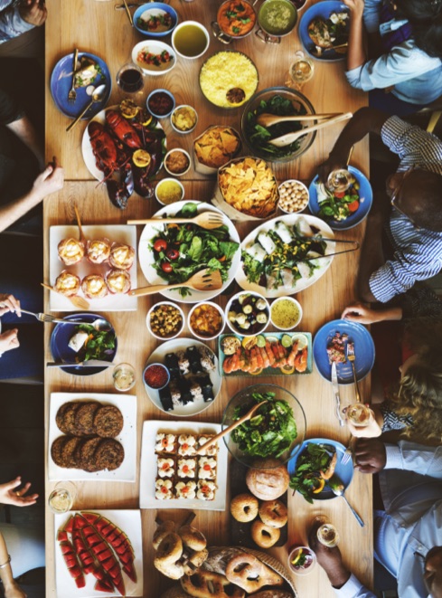 A long table seen from above, covered end to end with shared dishes