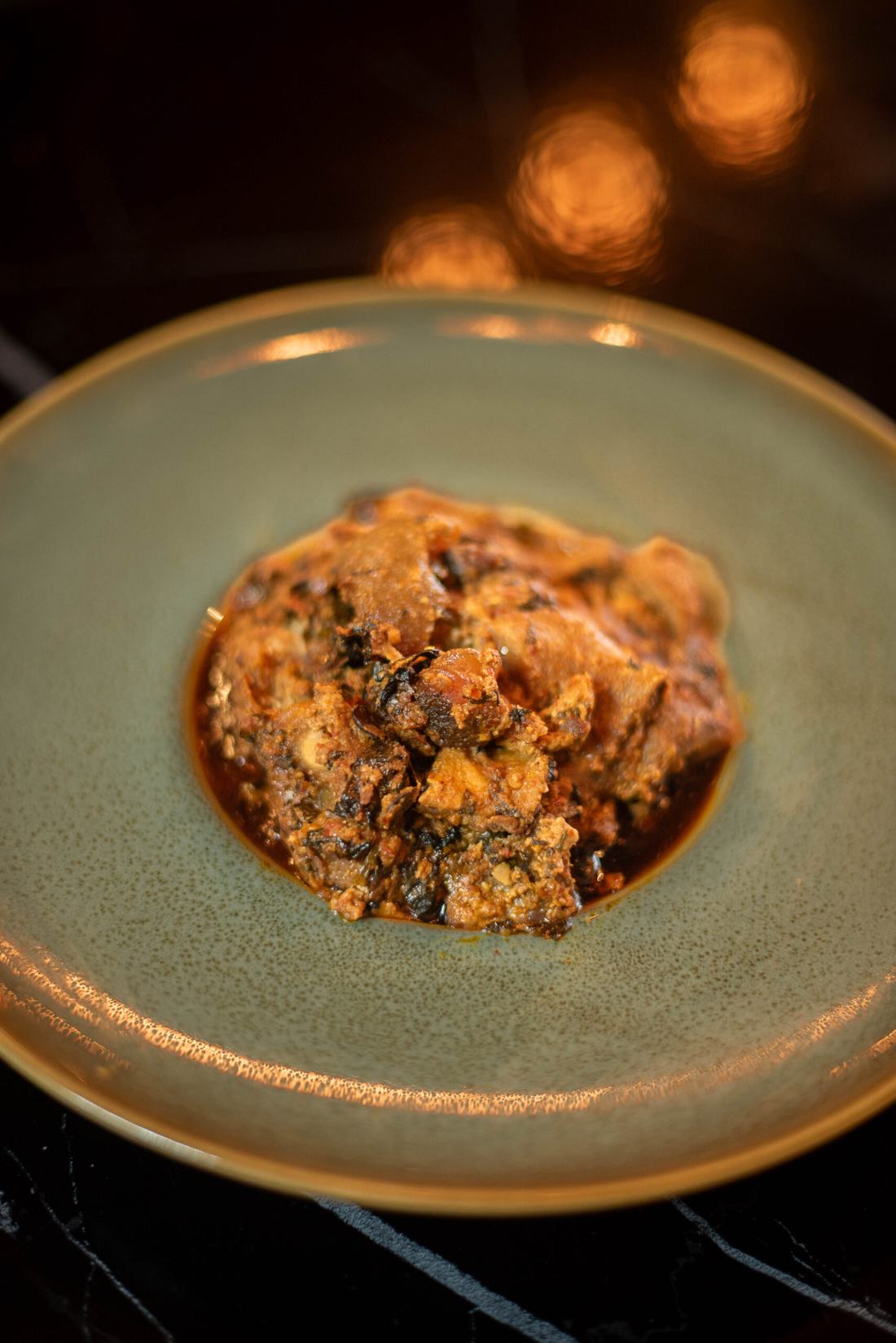 Egusi served on a green stoneware plate