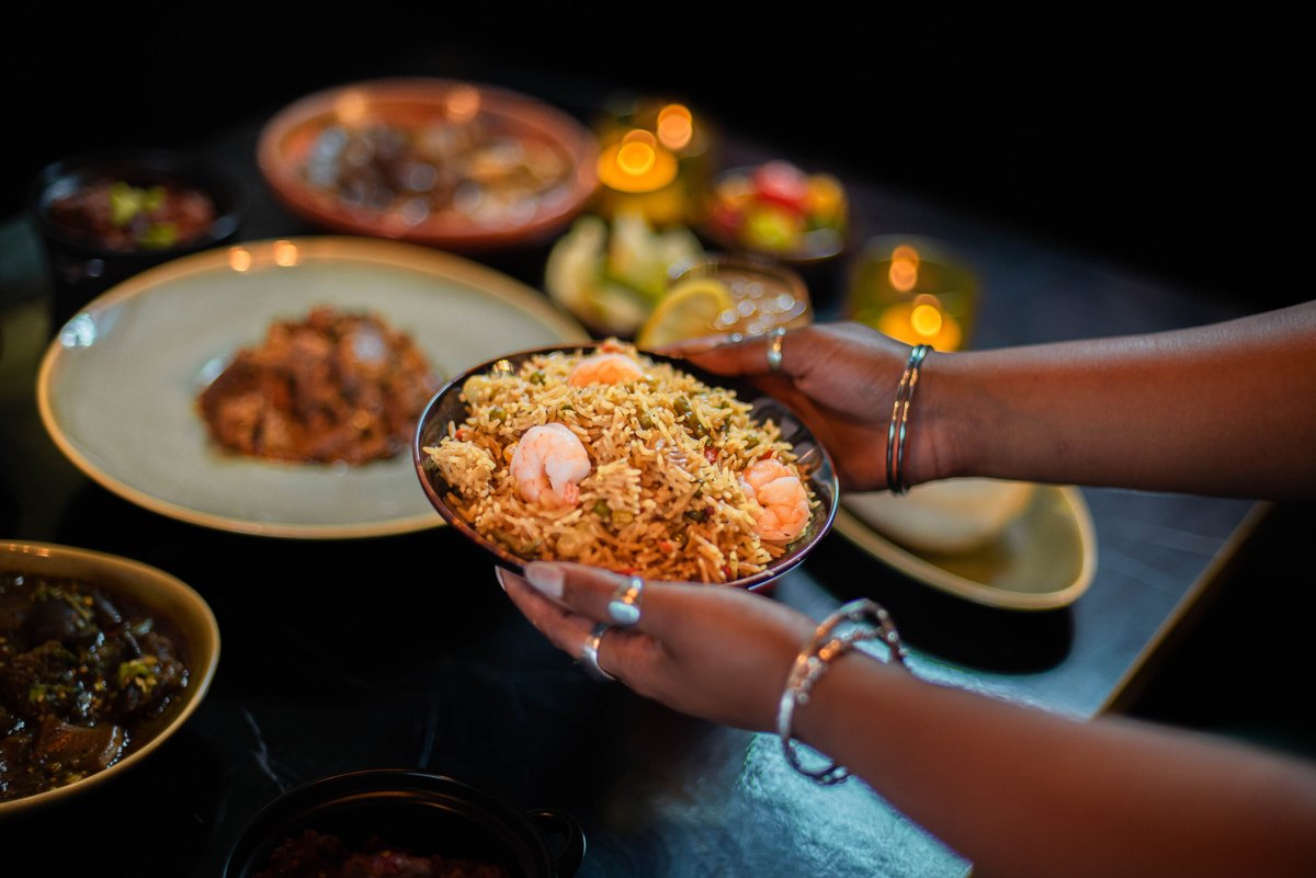 A bowl of rice being passed between two people at a table