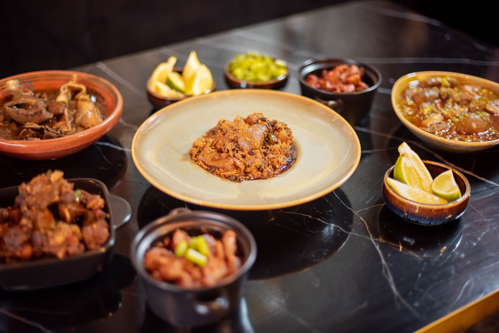 A table set with swallow, stews, peppered meats and sides